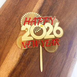 Detail of gold 2026 Happy New Year acrylic cake topper on rustic wood background