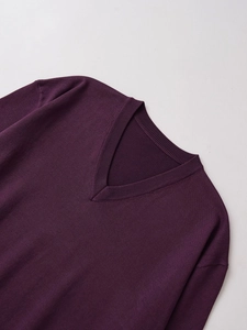 Vista dettagliata del maglione in maglia viola scuro con scollo a V e trama a coste classica