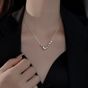 Elegant pearl heart pendant necklace featuring asymmetrical design on silver chain