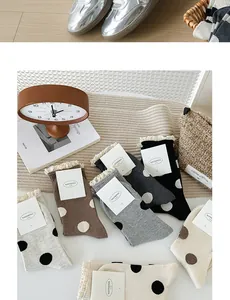 Dettaglio di calze a pois con delicati bordi in pizzo disponibili in vari colori tenui