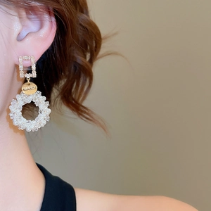 Detail of drop earrings with faux pearls and crystals on model for a luxury look