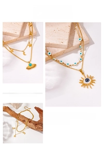 Detailed view of layered gold necklaces with star, moon, and blue evil eye charms