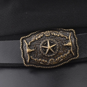 Detail of vintage bronze star buckle with bull head relief on a black flat top army cap
