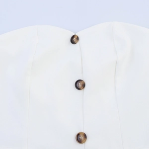 Women's white strapless vest top with tortoise shell buttons and slim fit suit trousers