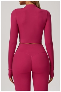 Vue arrière d'un ensemble de yoga rose vif ajusté avec legging et haut court de sport