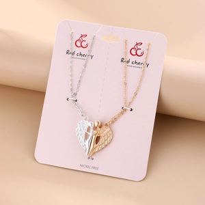 Detail of nickel-free angel wing magnetic heart pendants for couples on card