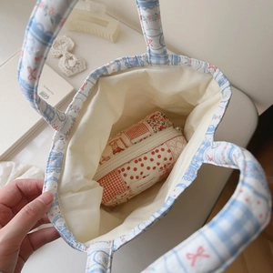 Top view of blue floral quilted tote bag interior with red polka dot zipper pouch