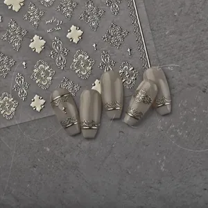 Detail view of gold and silver embossed nail stickers with European lace patterns