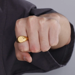 Close-up of a men's polished 18K gold plated stainless steel signet ring on a pinky finger