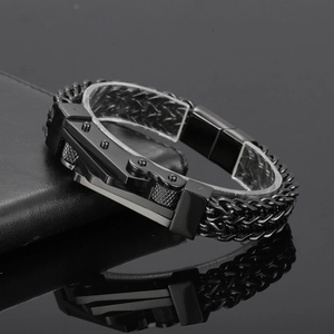 Detail shot of a black stainless steel motorcycle chain bracelet on a leather wallet