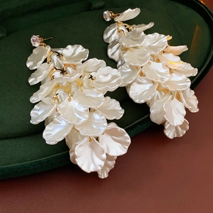 Dettaglio degli orecchini a nappa con petali in acrilico bianco su velluto verde