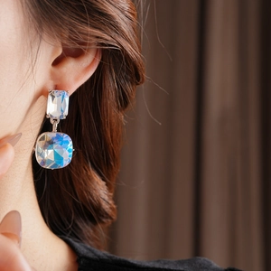 Detail of luxury square crystal drop earrings with sparkling tassels on model