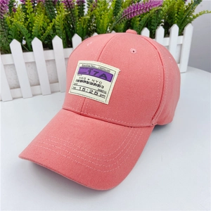 Detail of pink cotton baseball cap with vintage boarding pass patch showing travel theme