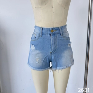Detail of high-waisted light blue denim shorts featuring distressed holes and frayed hems