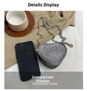 Detail view showing mini silver heart-shaped rhinestone bag size relative to a smartphone