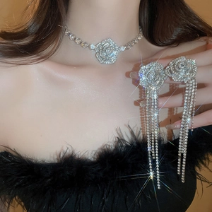 Luxury silver rose jewelry set with sparkling diamonds and long tassels worn by a model