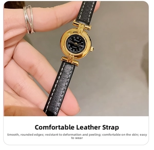 Close-up of DINIMI women's vintage quartz watch with black leather strap and gold dial