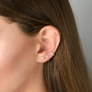 Minimalist gold plated earring set with cubic zirconia studs and ear cuffs on model