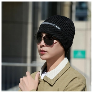 Detailed close-up of a men's thick knit thermal beanie with a fashion brand patch and stripe