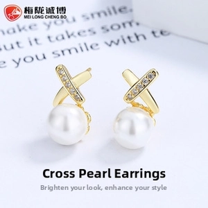 Macro detail of gold crisscross earrings with shell pearls and sparkling cubic zirconia