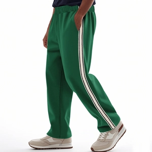 Detail of green men's straight-leg sports pants featuring black and white side stripes