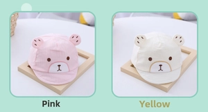 Detail of newborn cotton baby caps with bear ears in pink and beige colors