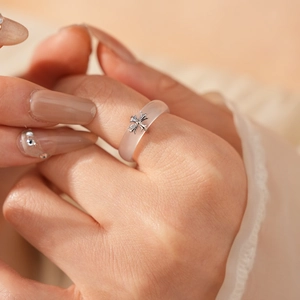 Detail view of a translucent chalcedony ring featuring a vintage silver metal cross icon