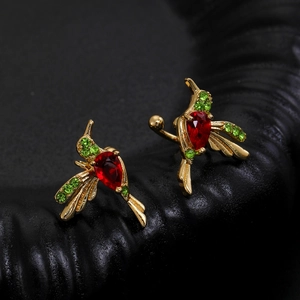 Macro detail of hummingbird ear cuffs featuring red teardrop and green zircon inlay