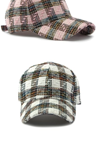 Detail van tweed honkbalpet met roze en zwarte geruite weefpatronen en textuur