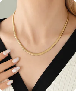 Detailopname van een gepolijste gouden slangenhalsketting gedragen op de nek van model