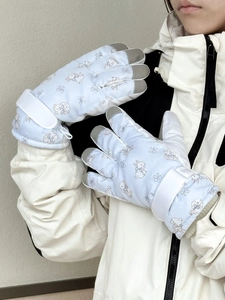 Detail of light blue ski gloves with cute rabbit prints and adjustable wrist straps