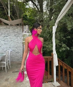 Detail of pink halter neck dress with cutout waist and elegant feather accessories