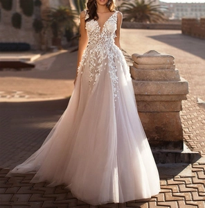 Detail of deep V-neck bridal gown with 3D floral appliques and layered tulle skirt