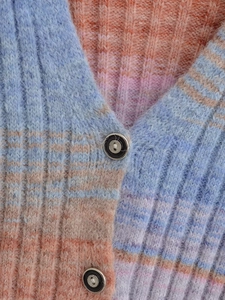 Detail of V-neck collar and black buttons on blue orange pink gradient knit cardigan