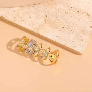 Detail shot of five gold and silver star moon rings with zircon on textured stone base