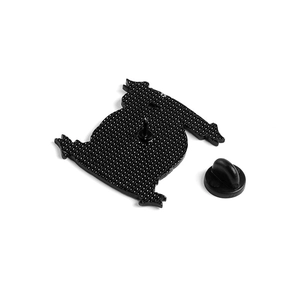 Detail of black enamel pin back featuring metallic needle and secure rubber clutch fastening