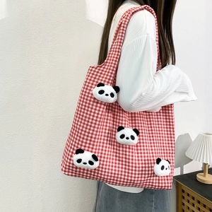Detail of red and white checkered tote bag with four cute plush panda doll decorations