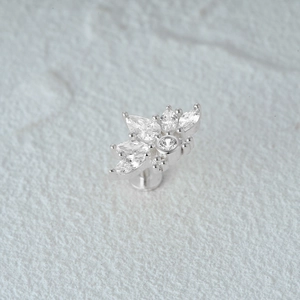 Macro view of silver flower cartilage stud earring with sparkling zircon gemstones