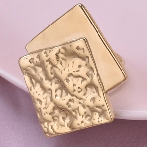 Detailed macro view of golden double-layer square ring with unique hammered metal texture