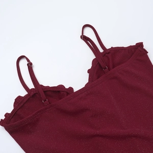 Dettaglio del top glitterato rosso scuro con bordi a balze e spalline regolabili