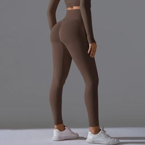Detail of high-waist yoga pants with peach butt lifting seams in chocolate brown fabric