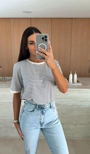 Gros plan d'un t-shirt à rayures et col rond avec un jean bleu clair à taille haute