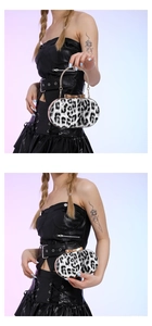 Close-up of black and white leopard print handbag with gold chain handle and metal frame