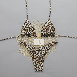 Flat lay of leopard print bikini set featuring metal hardware and high-cut bottoms