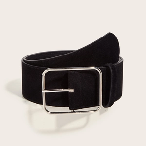 Detail of a wide black suede belt featuring a polished rectangular silver buckle