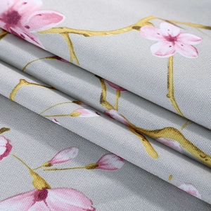 Close-up of linen microwave dust cover featuring pink cherry blossom patterns on grey fabric