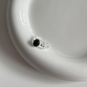 Macro shot of 925 sterling silver hammered ring featuring an oval black onyx gemstone