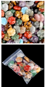 Macro shot of assorted natural crystal cat paw charms and packaging on black background