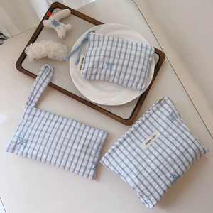 Detail of blue plaid cotton bags with bow embroidery and 'simple wish' label tags