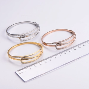 Three-piece metal bangle set in gold, silver, and rose gold with pavé rhinestone accents